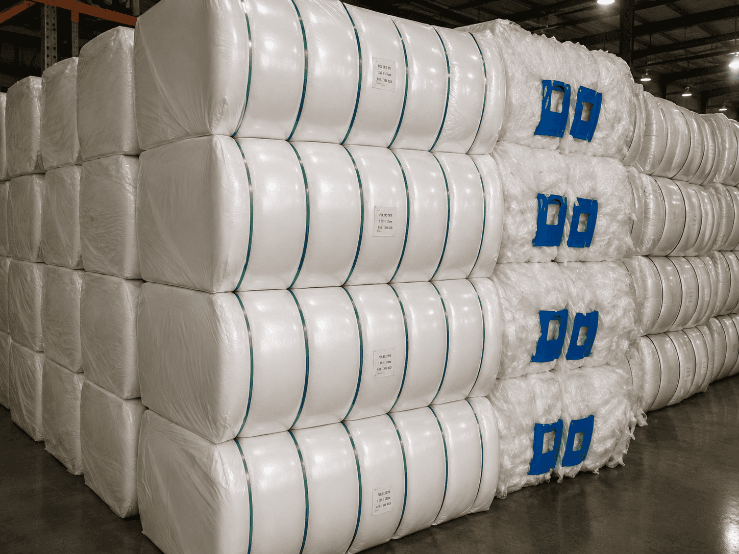 Stacks of compressed polyester fiber bales protected for warehouse storage