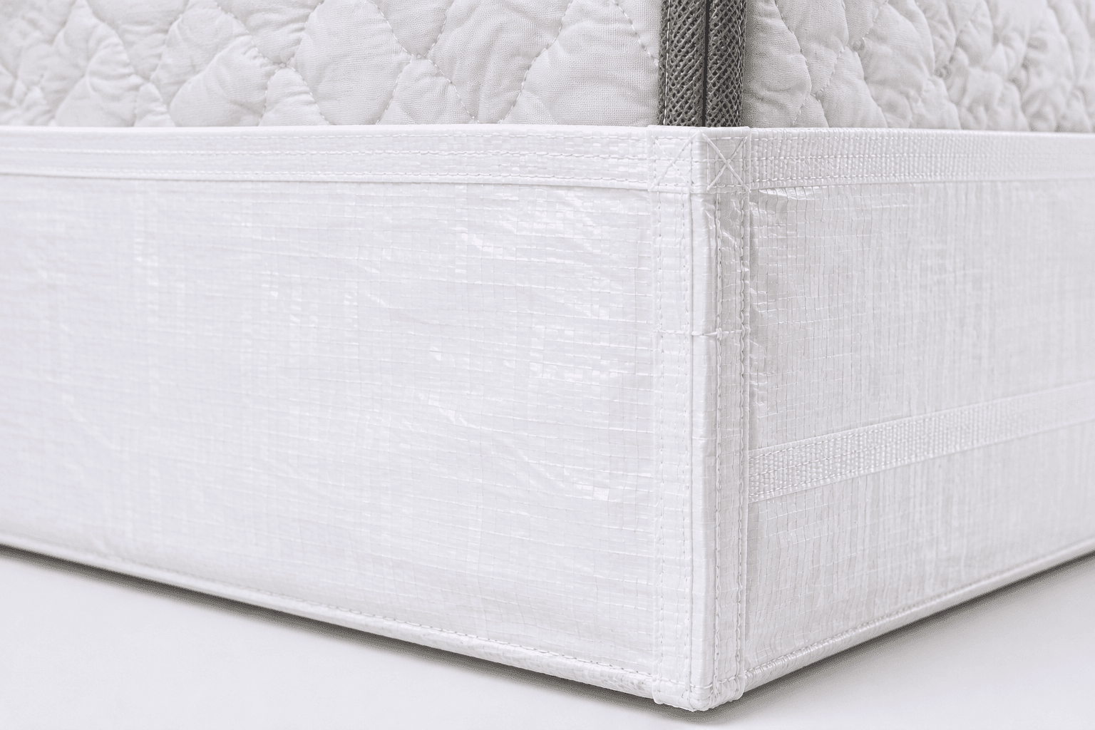 Close-up of reinforced stitching and woven polypropylene construction on a mattress boot